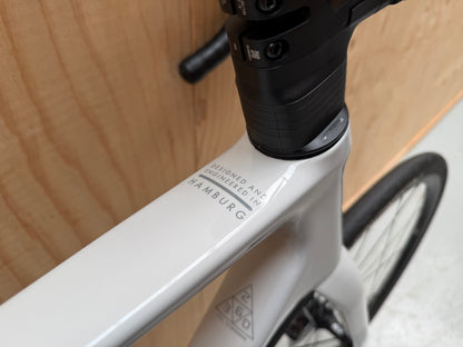 Stevens Izoard PRO Disc wielrenfiets met zwarte frame en schijfremmen, close-up van het voorwiel en framemerk op de fiets