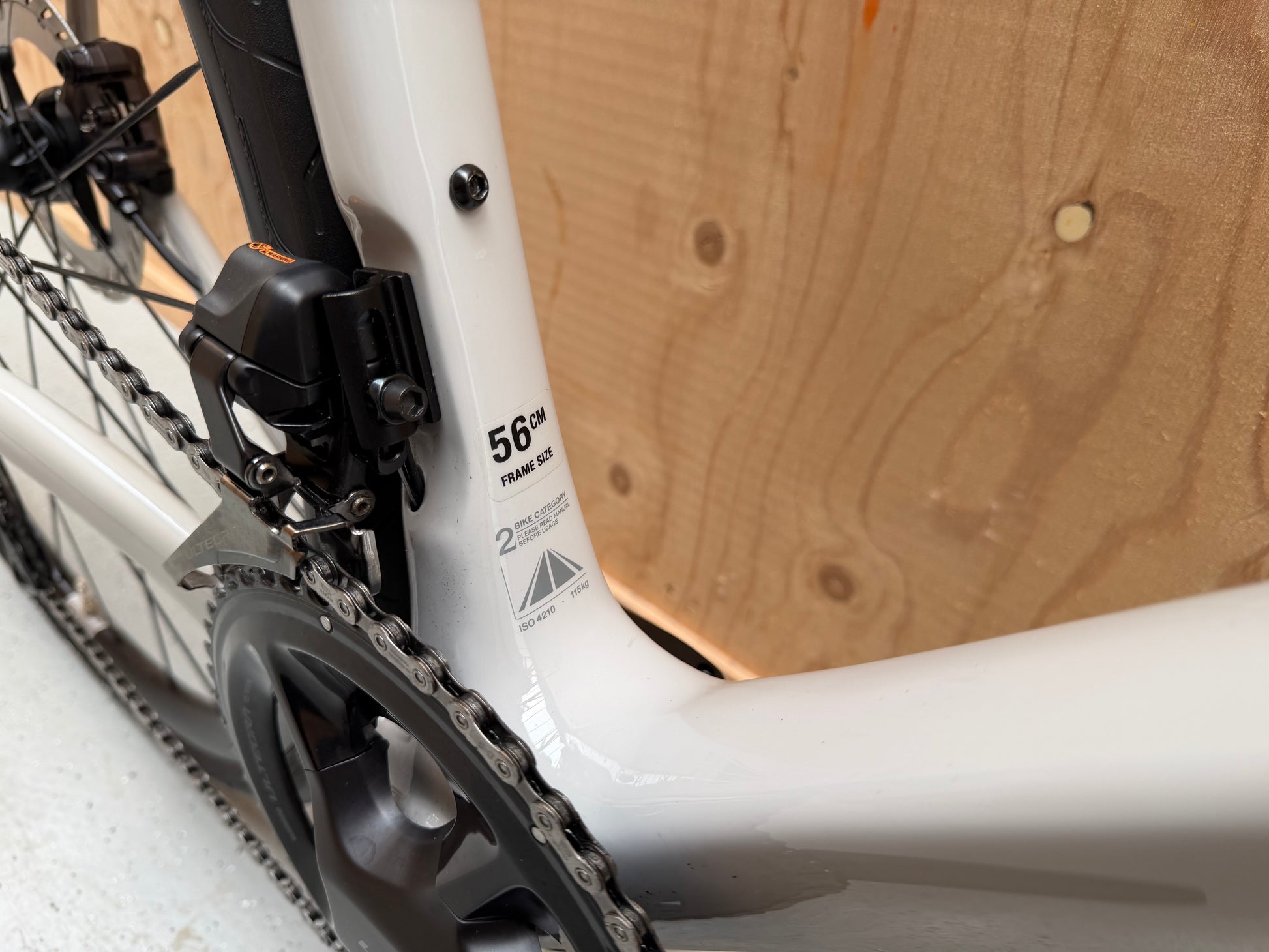 Stevens Izoard PRO Disc racefiets van Velostudio, close-up van frame en wiel, zwart met rode accenten, lichte en aerodynamische structuur