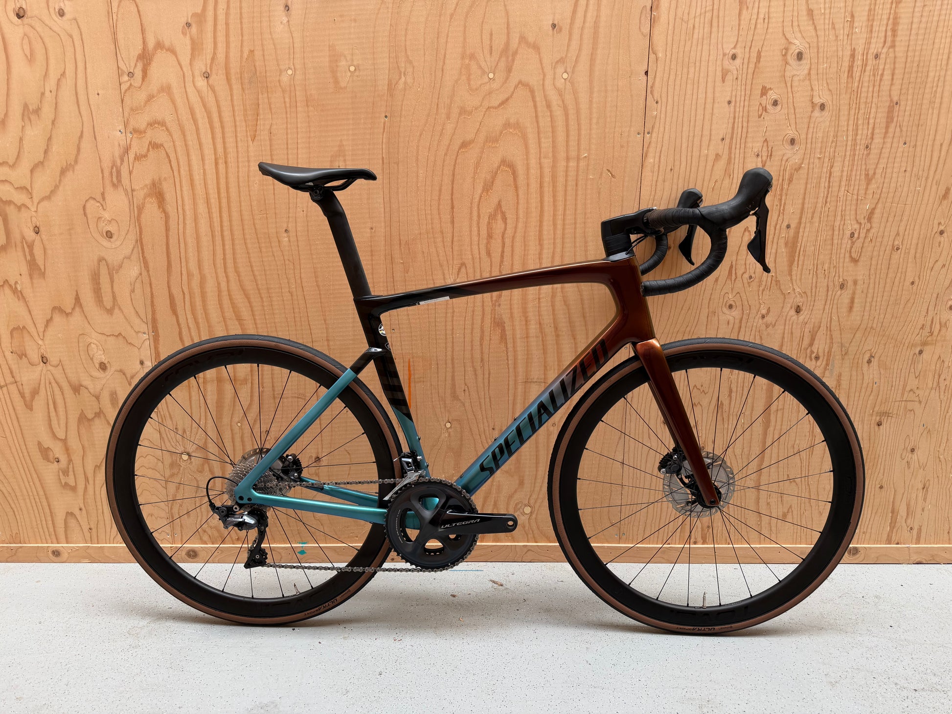 Zwart Specialized Tarmac SL7 Expert racefiets met aerodynamisch frame en dunne banden, foto van vooraanzicht op een witte achtergrond