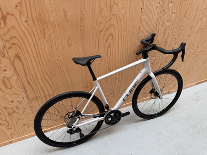 Zwart Cube Attain C:62 SLX racefiets met aerodynamisch frame en carbon wielen, Velostudio logo zichtbaar op de fiets.