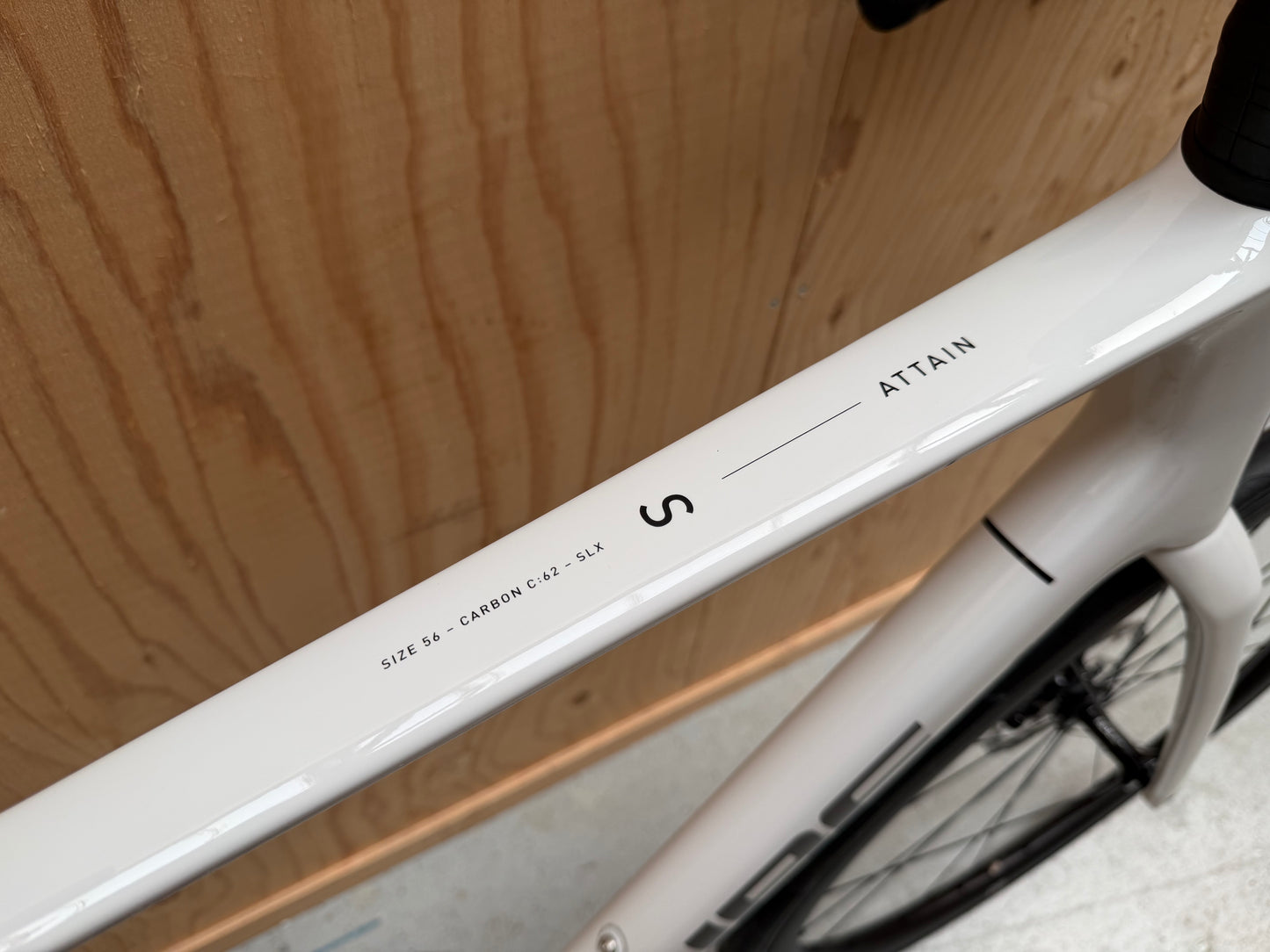 Cube Attain C:62 SLX racefiets van Velostudio, zwart met blauwe accenten, zichtbaar vanaf de zijkant op een witte achtergrond.