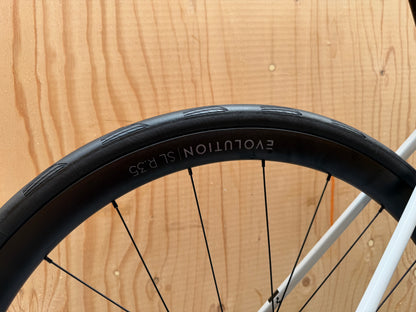Cube Attain C:62 SLX racefiets van Velostudio, zwart met blauwe accenten en luxe afwerking, zichtbaar in de foto.