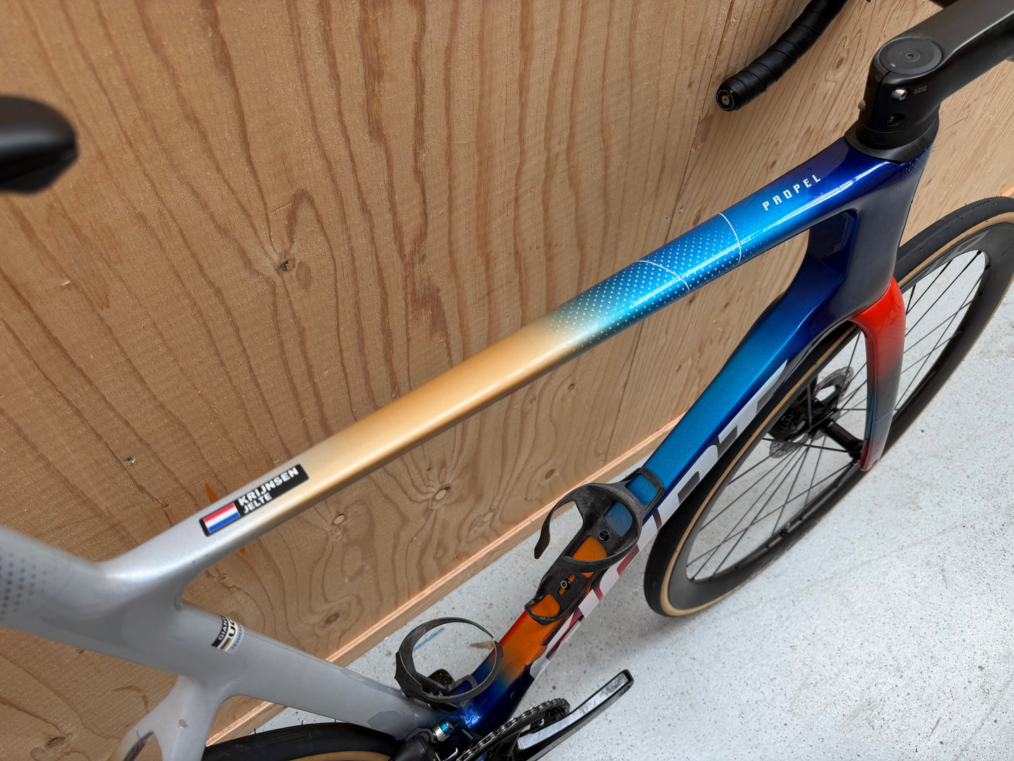 Giant Propel Advanced SL racefiets met Team Jacyo AlUla branding, zwart en geel frame, geplaatst op een weg.