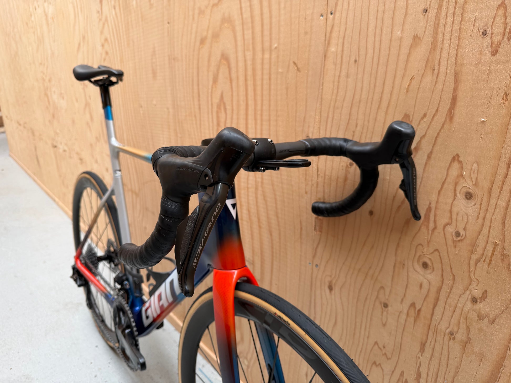 Lichtgewicht Giant Propel Advanced SL racefiets met Team Jacyo AlUla branding, zwart en rood, op een fietsstandaard.