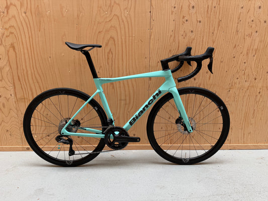 Zwart Bianchi Specialissima Comp racefiets met lichtgewicht frame en aerodynamische onderdelen, gemaakt door Velostudio.
