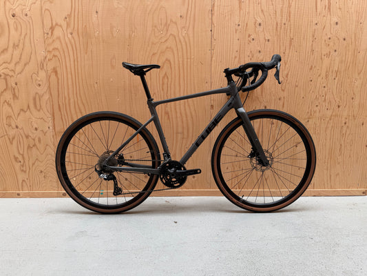 Fietsfoto van de Velostudio Cube Nuroad GRX gravelbike met zwart frame en brede banden, klaar voor avontuur.