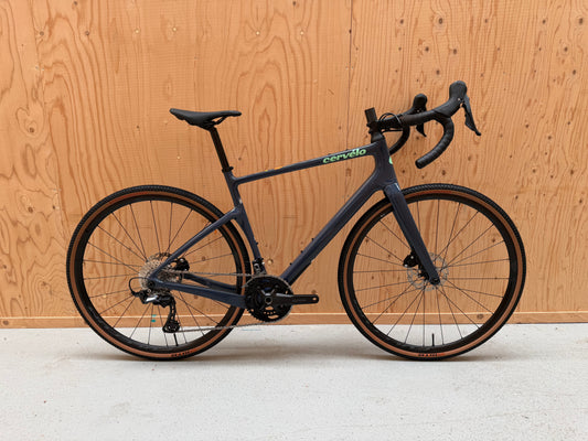 Cervelo Aspero gravelbike met GRX RX610 groep, zwart met gele accenten, klaar voor off-road rijden.