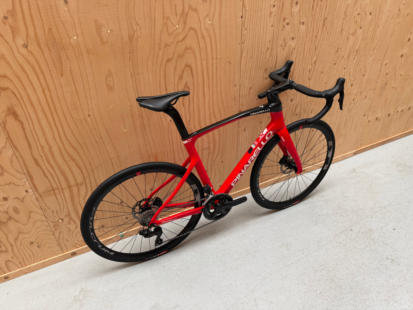 Racefiets Pinarello X3 van Vélo Studio met aerodynamisch frame en dunne banden, klaar voor snelle ritten.