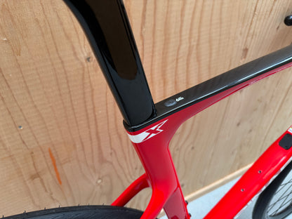 Zwart Pinarello X3 racefiets met aerodynamisch frame en dunne banden, geschikt voor wielrennen, op een witte achtergrond.