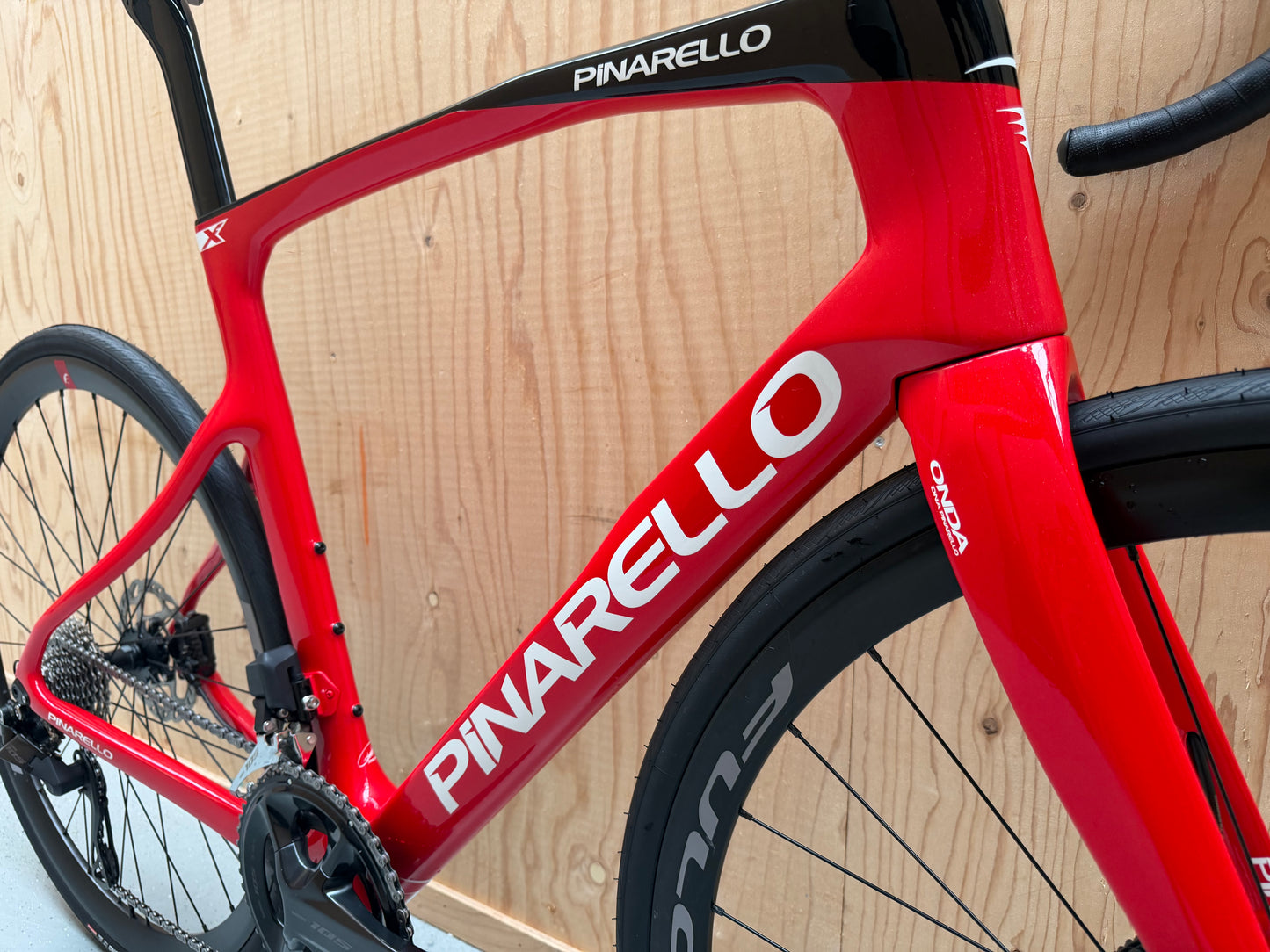 Zwart Pinarello X3 racefiets met aerodynamisch frame en comfortabele zitpositie, gepresenteerd door Vélo Studio.