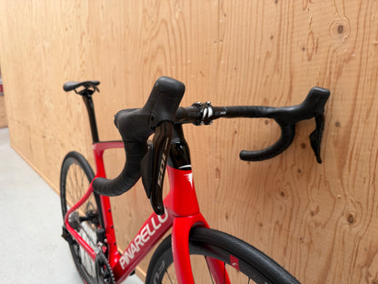 Zwart Pinarello X3 racefiets met aerodynamisch frame en dunne banden, geplaatst op een weg.
